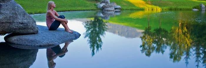 woman sitting near pond